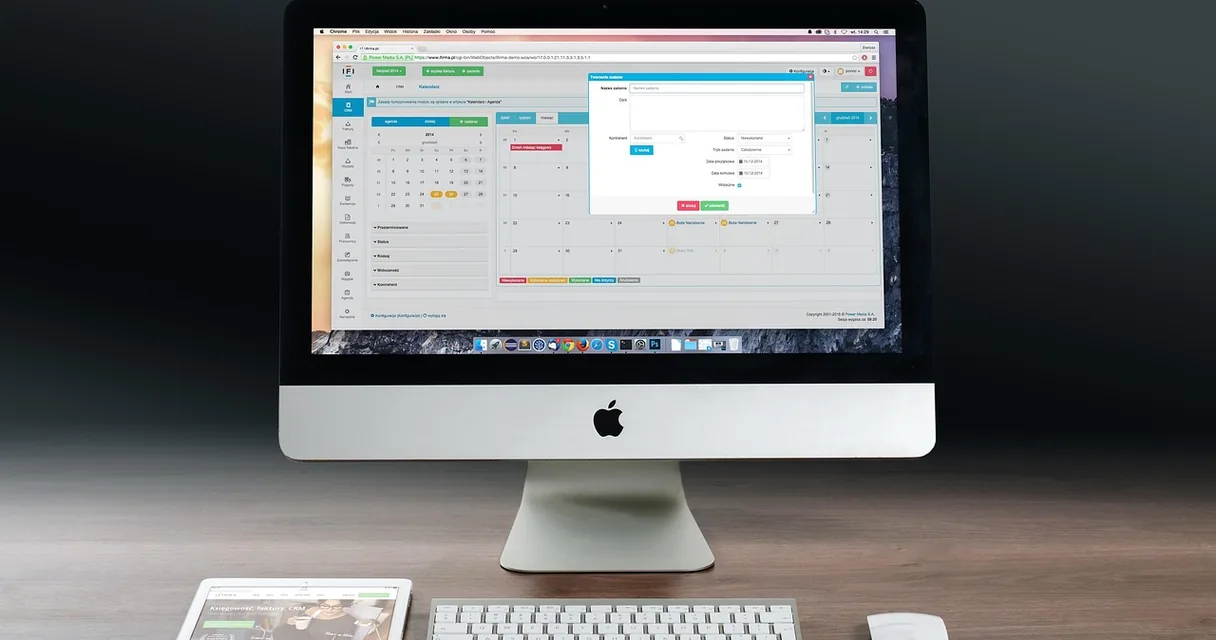 Computador com calendário aberto na tela, sobre mesa de trabalho