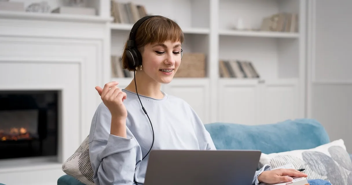 Mulher de fones de ouvido estudando em um notebook na sala de casa