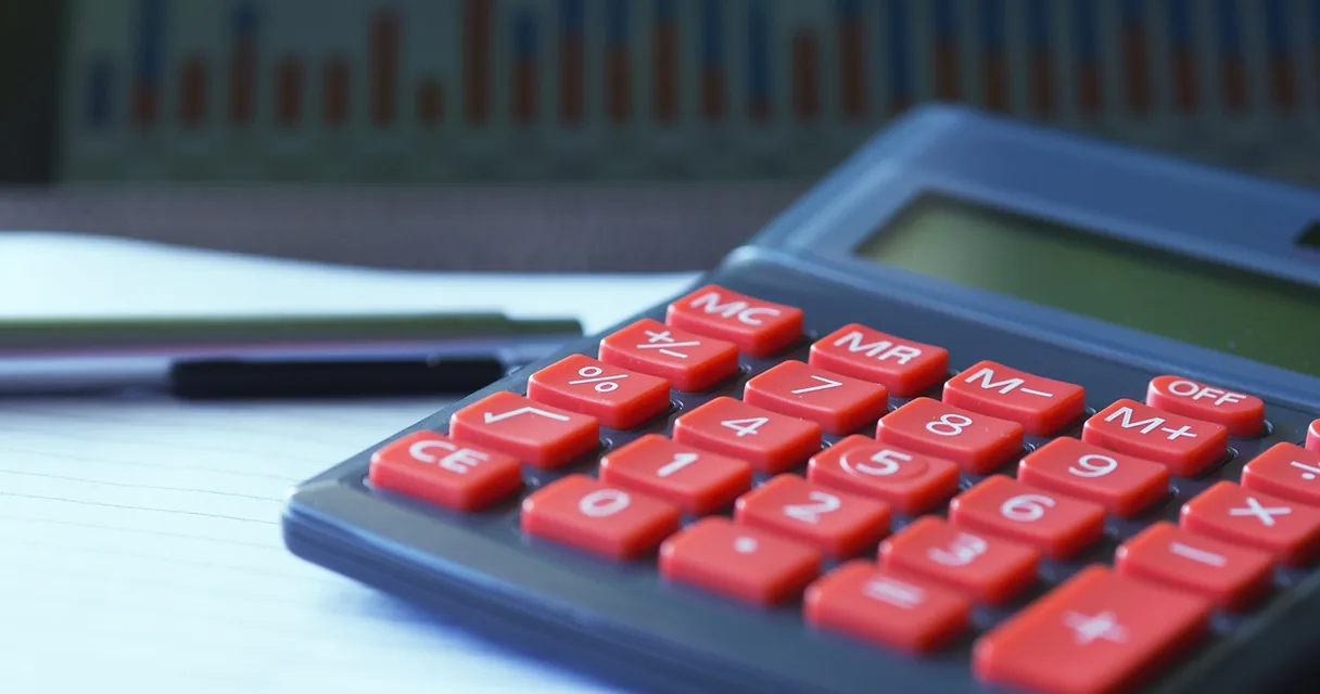 Calculadora sobre um caderno em uma mesa de trabalho